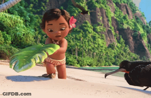 A Little Girl With A Flower In Her Hair Is Standing On A Beach Holding A Green Object GIF