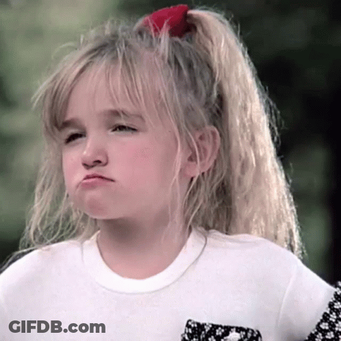 A Little Girl With A Red Bow In Her Hair Is Making A Face GIF