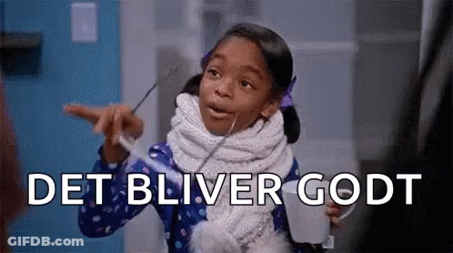 A Little Girl With A Scarf Around Her Neck Is Holding A Cup And Pointing At The Camera . GIF