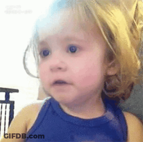 A Little Girl With Blonde Hair Is Wearing A Blue Tank Top And Making A Surprised Face . GIF