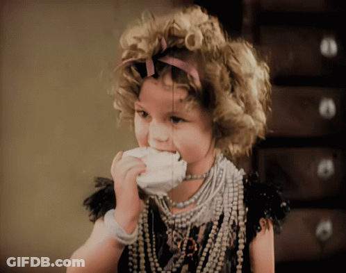 A Little Girl With Curly Hair And A Necklace With The Letter R On It GIF