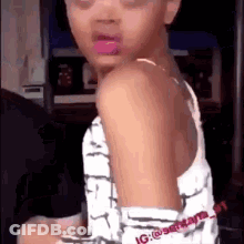 A Little Girl With Pink Lipstick On Her Lips Is Sitting In A Chair And Looking At The Camera . GIF