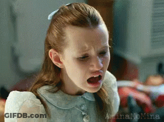 A Little Girl With Red Hair Is Making A Funny Face With Her Mouth Open . GIF