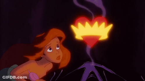 A Little Mermaid Looks At A Heart With A Crown Coming Out Of It GIF