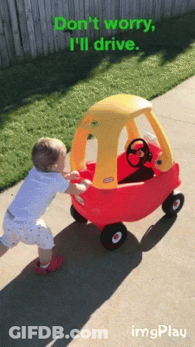 A Little Tikes Cozy Coupe Is Being Pushed By A Young Boy GIF