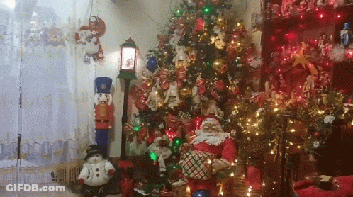 A Living Room Decorated For Christmas With A Christmas Tree And Santa Claus GIF