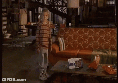 A Living Room With A Couch And A Coffee Table With A Bag Of Chips On It GIF
