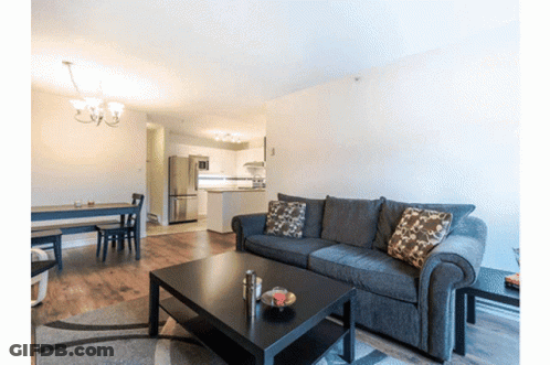 A Living Room With A Couch And A Table GIF