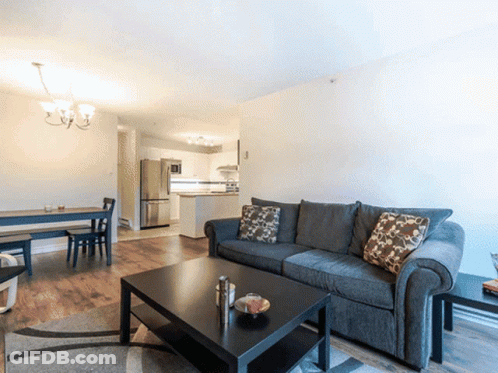 A Living Room With A Couch And A Table GIF