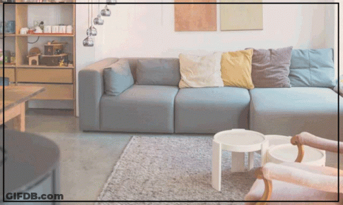 A Living Room With A Couch And Two Tables And A Shelf With Toys On It GIF