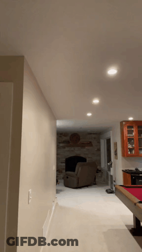 A Living Room With A Pool Table And A Chair GIF