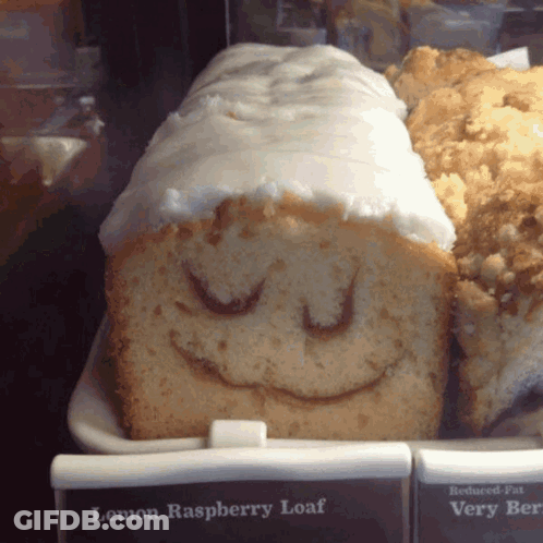 A Loaf Of Lemon Raspberry Loaf With A Smiling Face Drawn On It GIF