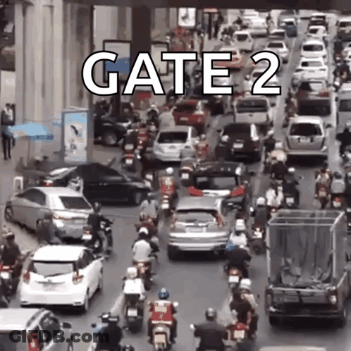 A Lot Of Cars And Motorcycles Are Driving Down A Street With The Words Gate 2 On The Bottom . GIF