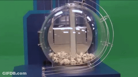 A Lottery Machine Filled With Balls And A Green Background GIF