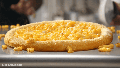 A Macaroni Cheese Pizza Is Sitting On A Pan GIF