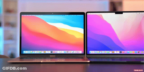 A Macbook Air Sits Next To Another Laptop On A Table GIF