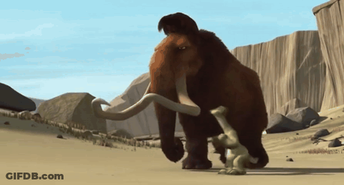 A Mammoth Standing Next To A Smaller Mammoth In A Desert GIF