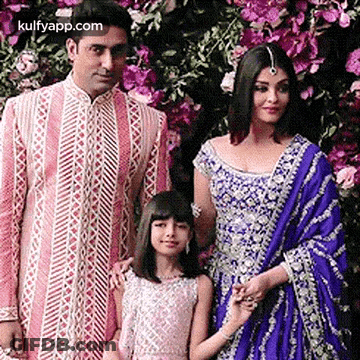 A Man , A Woman And A Little Girl Are Posing For A Picture Together . GIF