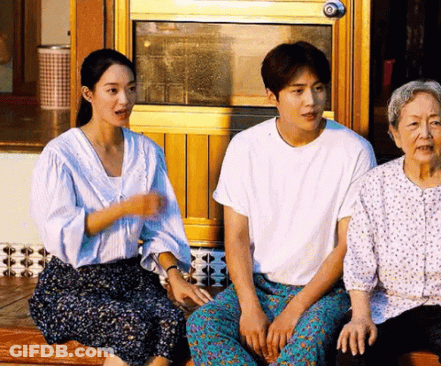 A Man , A Woman And An Older Woman Are Sitting On A Porch . GIF