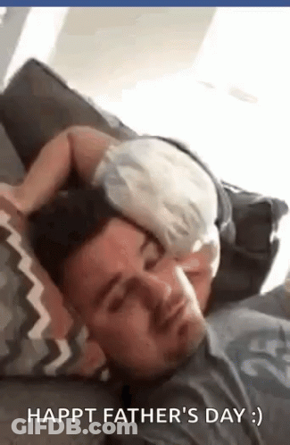 A Man And A Baby Are Laying On A Couch . GIF