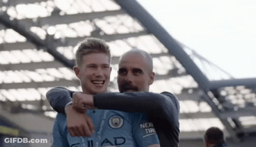 A Man And A Boy Are Hugging Each Other And Smiling . GIF