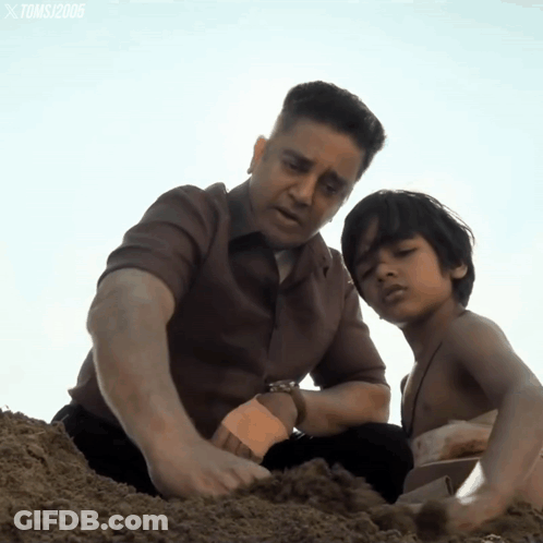 A Man And A Boy Are Playing In The Sand And The Watermark Toms 2006 Is On The Bottom Right GIF