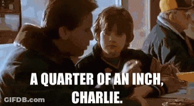 A Man And A Boy Are Sitting At A Table With The Words " A Quarter Of An Inch Charlie " On The Bottom GIF