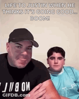 A Man And A Boy Are Sitting Next To Each Other And The Man Is Holding The Boy 'S Arm . GIF