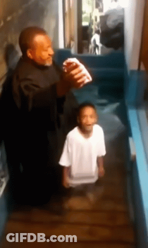 A Man And A Boy Are Standing In A Hallway And The Boy Is Wearing A White Shirt GIF