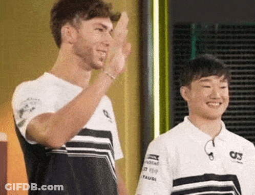 A Man And A Boy Are Standing Next To Each Other And One Of Them Is Waving . GIF