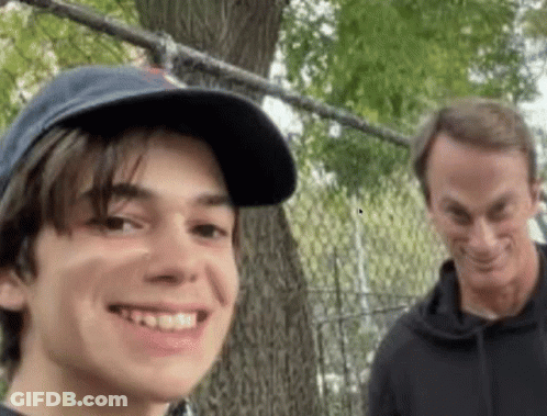 A Man And A Boy Are Standing Next To Each Other And Smiling GIF