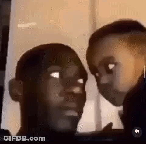 A Man And A Child Are Looking At Each Other And Making Funny Faces . GIF