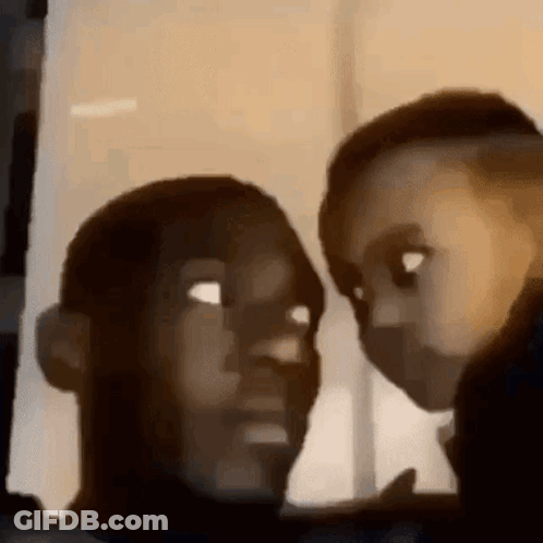 A Man And A Child Are Looking At Each Other In A Dark Room . GIF