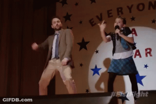 A Man And A Girl Are Dancing In Front Of A Sign That Says " Everyone " GIF