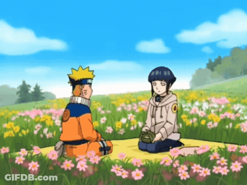 A Man And A Girl Are Sitting In A Field Of Flowers GIF