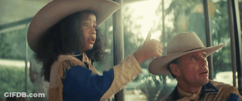A Man And A Girl In Cowboy Hats Are Looking Out A Window GIF