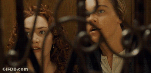 A Man And A Woman Are Behind A Fence And The Woman Is Giving The Middle Finger GIF