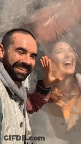 A Man And A Woman Are Behind A Plastic Bubble And The Man Is Smiling GIF