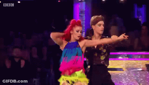 A Man And A Woman Are Dancing A Dance On A Stage . GIF