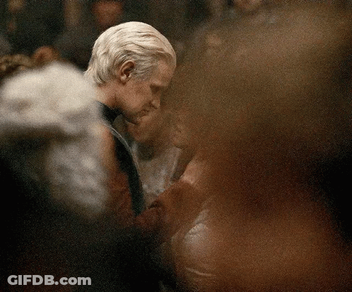A Man And A Woman Are Dancing In A Crowded Room . GIF
