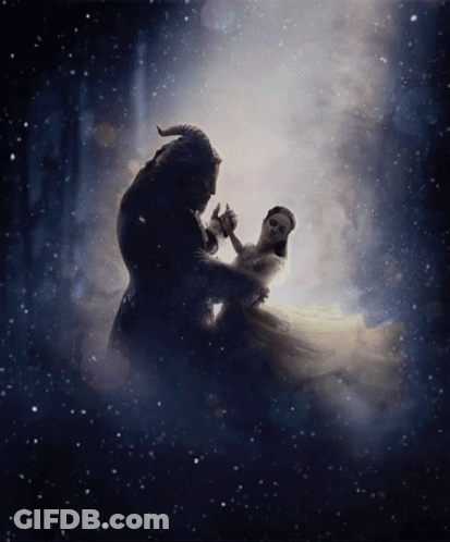 A Man And A Woman Are Dancing In A Dark Room . GIF