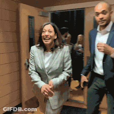 A Man And A Woman Are Dancing In A Hallway GIF