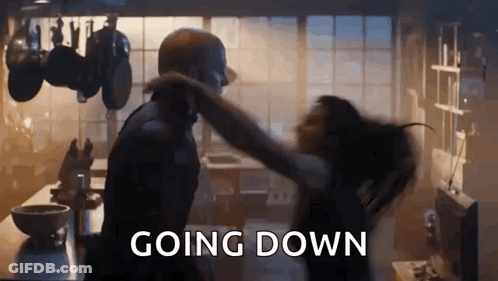 A Man And A Woman Are Dancing In A Kitchen With The Words `` Going Down '' Written On The Bottom . GIF