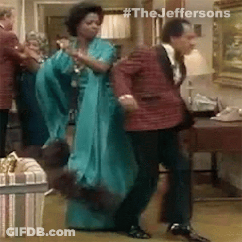 A Man And A Woman Are Dancing In A Room . GIF