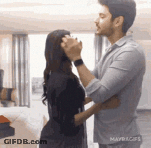 A Man And A Woman Are Dancing In A Room . GIF