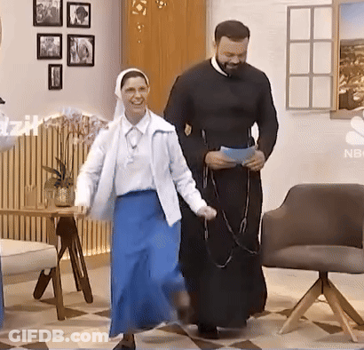 A Man And A Woman Are Dancing In A Room With A Nbc Logo On The Wall GIF