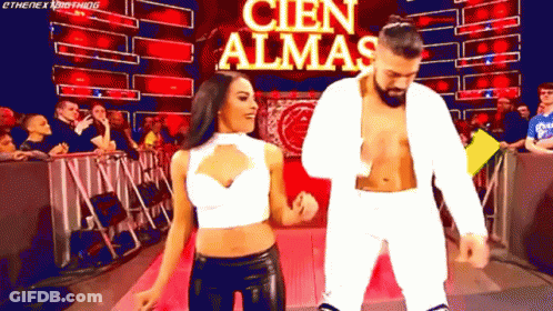 A Man And A Woman Are Dancing In Front Of A Banner That Says Cien Almas GIF