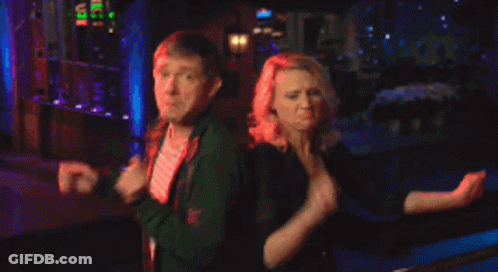 A Man And A Woman Are Dancing In Front Of A Building GIF