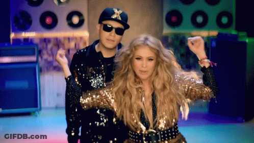 A Man And A Woman Are Dancing In Front Of A Bunch Of Record Players GIF