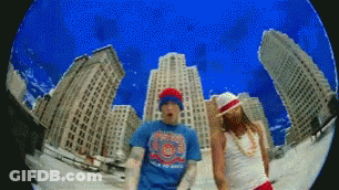 A Man And A Woman Are Dancing In Front Of A Cityscape GIF